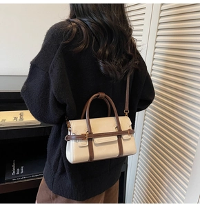 Dettaglio della borsa a tracolla vintage beige e marrone indossata da una modella