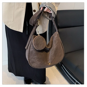 Detail of vintage matte leather dark brown crescent bag with small round coin purse charm