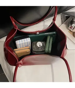 Deep red pleated tote bag interior with magnetic clasp and spacious inner compartment