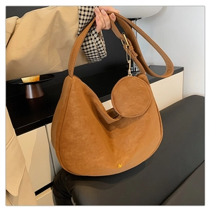 Close-up of vintage brown frosted leather hobo bag with small round coin purse attachment