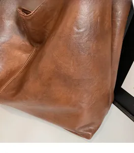 Macro shot of smooth caramel brown leather texture on a high-capacity tote bag