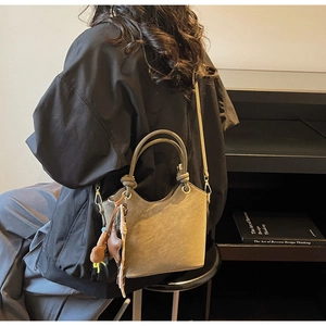 Brown bucket bag on a model with round knotted handles and a star charm detail