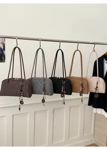 Detailed row of five minimalist faux suede shoulder bags with retro beaded charms
