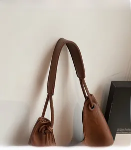 Close-up of wide stitched shoulder strap on a brown retro soft leather tote bag