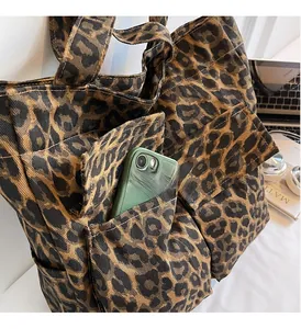 Close-up of leopard print canvas tote bag featuring a practical outer pocket for phone storage