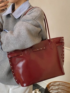 Large burgundy leather tote bag with silver studs and belt detail for casual commuting