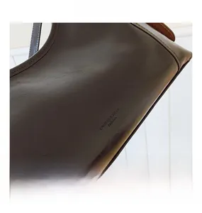 Macro detail of high-quality embossed leather texture and brand logo on shoulder bag