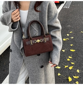 Deep brown square handbag with gold heart lock shown in autumn street style aesthetic