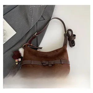 Detail of coffee suede tote bag with leather bow, star patches and colorful charms