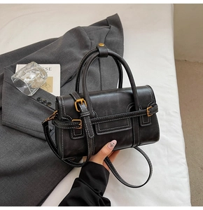 Dettaglio della mini borsa vintage nera con cuciture bianche a contrasto e fibbia oro