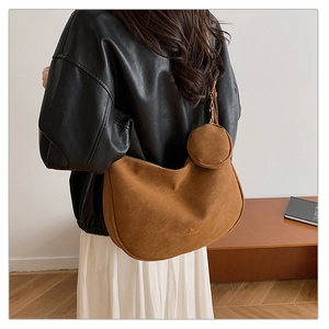 Detail view of brown matte suede hobo bag with matching round coin purse pendant