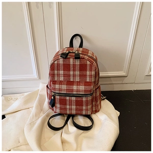 Detail shot of the red and white tartan textured wool fabric and black leather handle