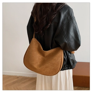 Caramel matte leather hobo bag side view on model showing spacious crescent shape