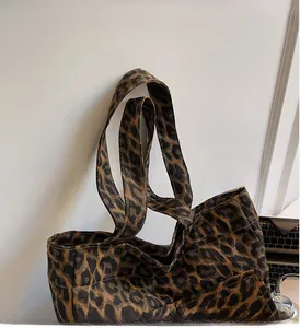 Detail of leopard print canvas tote bag featuring double handles and front pocket
