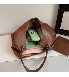 Top view of large brown leather tote showing spacious interior with tablet and daily items
