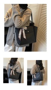 Gros plan sur un sac cabas noir en cuir grainé avec foulard décoratif et bouton doré
