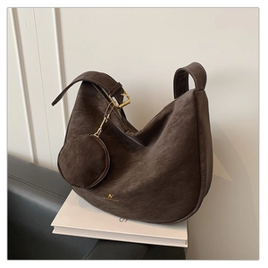 Macro detail of dark brown suede crescent bag texture with vintage gold logo and hardware