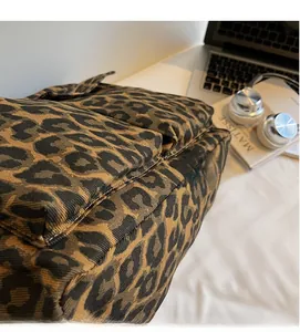 Close-up of leopard print canvas tote bag showing soft texture and outer zipper pocket