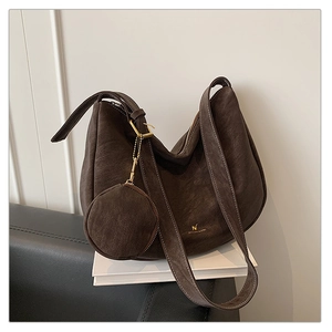 Close-up of matte dark brown half-moon tote bag with fine stitching and coin purse charm