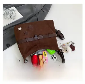 Close-up of brown suede shoulder bag interior showing daily items like phone and lipstick