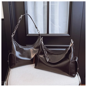 Detail view of two dark coffee oily leather tote bags in large and small sizes
