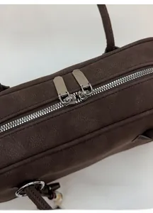Close-up of premium double silver zippers on dark brown matte leather shoulder bag