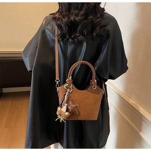 Caramel brown leather bucket bag with cute bear charm and star pendant detail