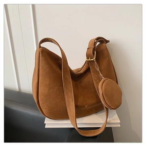 Detail of tan suede hobo bag featuring adjustable strap and a matching mini round coin purse