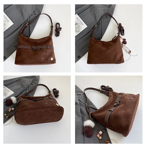 Detail view of brown suede shoulder bag featuring star patches and bow decoration