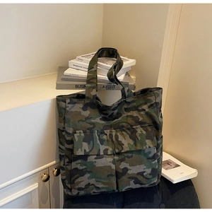 Detail of high-capacity camouflage canvas tote bag featuring dual front flap pockets