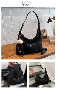 Detail view of black suede tote bag with bow strap and decorative star patch accents