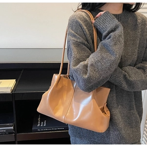 Detail of camel brown pleated tote bag in soft PU leather with a vintage textured design