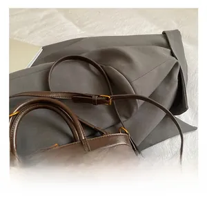 Detailed close-up of dark brown bucket bag with adjustable leather strap and stitching