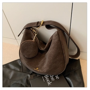Detail of dark brown matte leather hobo bag with a matching round coin purse and gold hardware