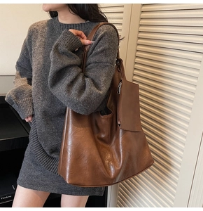 Detail of soft brown leather tote bag with small zipper pouch and textured finish