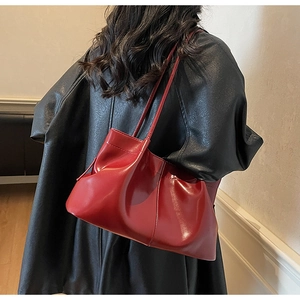 Detail of red pleated leather tote bag with cloud texture and slim shoulder strap