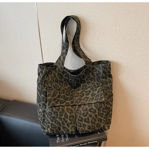 Detail of dark green leopard canvas tote showing dual front pockets and durable handles