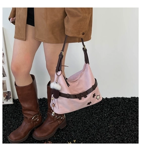 Pink hobo shoulder bag featuring a dark brown bow accent and plush charm accessory