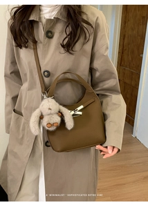 Brown retro leather bucket bag with silver buckle and cute plush rabbit charm detail
