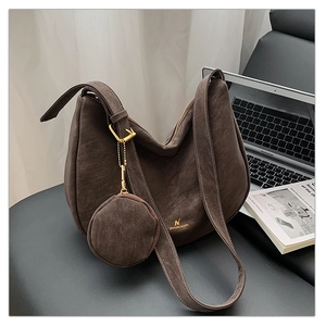 Detail of dark brown matte leather hobo bag with gold logo and round coin purse attachment