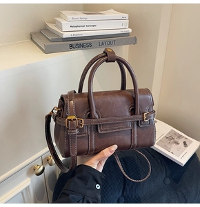 Dettaglio della borsa retrò marrone scuro con fibbia dorata e cuciture a contrasto