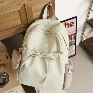 Detailansicht des cremefarbenen Nylon-Rucksacks mit Kordelzug-Schleife und kleinem Rundbeutel