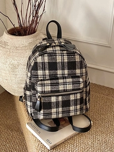 Classic black and white houndstooth backpack with leather straps and gold metal zippers