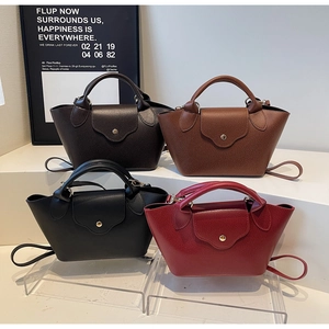 Detail of four litchi grain leather dumpling bags in dark brown, caramel, black, and burgundy