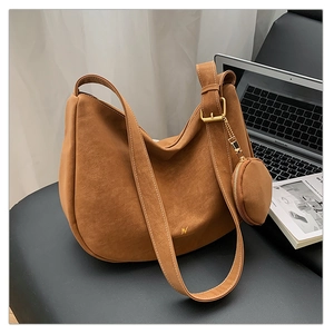 Detail view of brown matte suede tote bag with small round coin purse and gold hardware