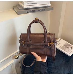 Dettaglio borsa a mano vintage marrone con cuciture a contrasto e fibbia metallica