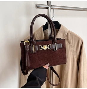 Detail of vintage coffee shoulder bag with heart clasp and suede leather splicing