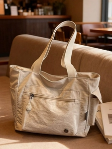 Large beige nylon tote bag with front zipper pocket and side pockets for casual daily commute