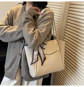 Detail of cream tote bag with lychee grain leather and silk scarf on handle