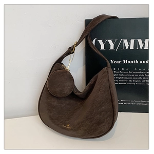Detailed macro of dark brown matte finish bag with golden logo and half-moon design